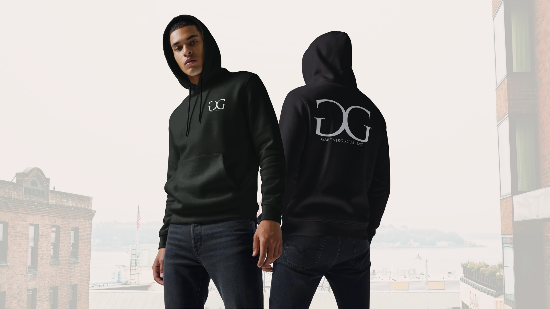 Man wearing a black hoodie with a GardnerGlobal logo, standing in an urban setting.